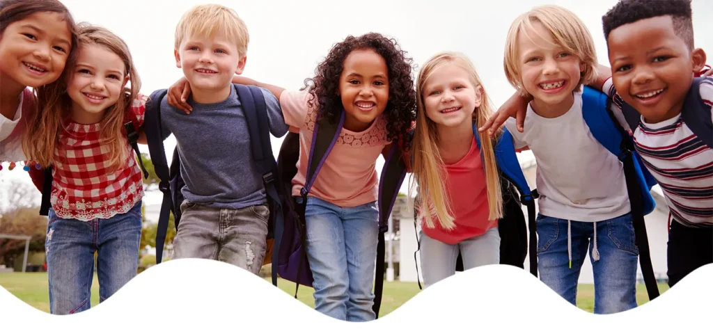 Smiling diverse elementary school students standing together outdoors at New Pacific Charter.