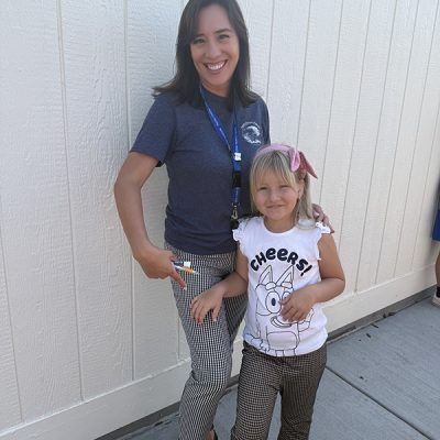 a teacher and student standing in front of a building